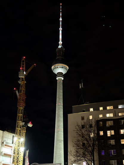 The Berliner Fernsehturm (TV tower) with lighting coming so strongly from the bottom, that the top half of the "disco ball" is barely visible. The light does hit the antenna above it.

Taken in Mitte.