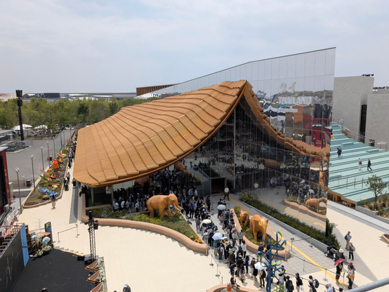 Blick auf den Pavillon von Thailand mit einem kurvig gespannten Dach aus bräunlich-gelben Dachziegeln.