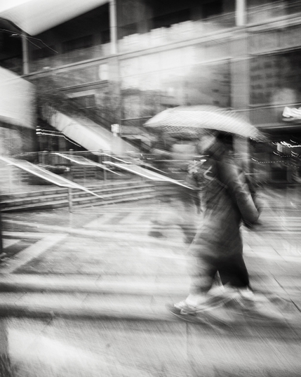 Black and white photo of person holding an umbrella.