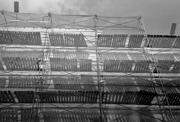 A monochrome photo shows scaffolding and its shadows.