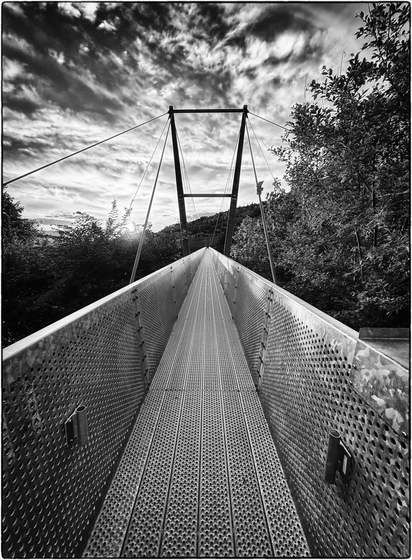 Schwarzweissfotografie einer Hängebrücke am Startpunkt