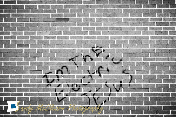 Graffiti “I’m the Electric Jesus” on a brick wall. 
