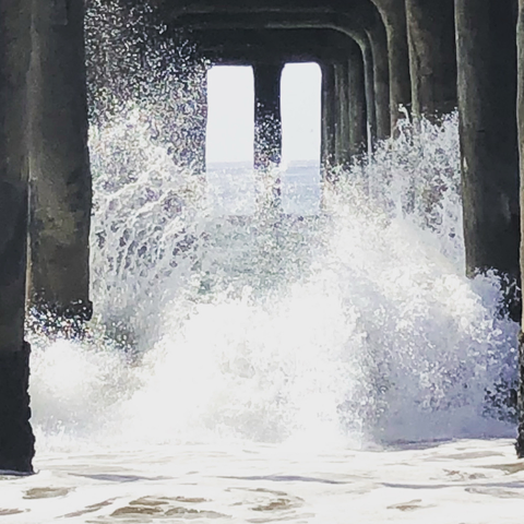Waves crash under the Manhattan Beach Pier 