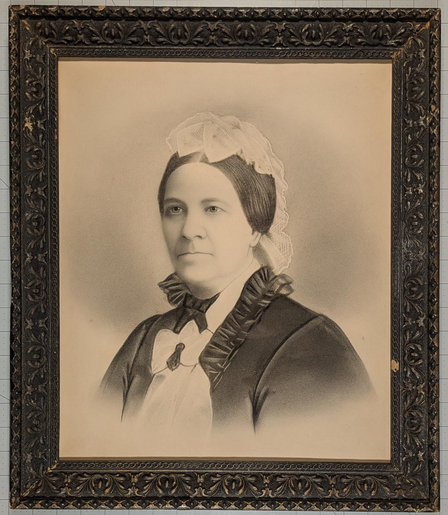 An antique sepia crayon portrait of a woman from around 1890 in an ornate black frame
