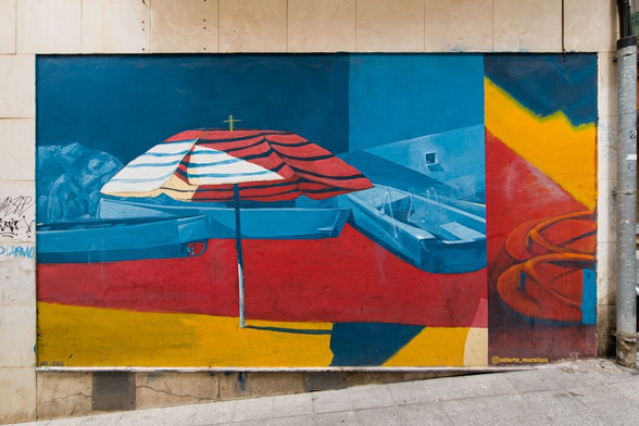 A mural of an umbrella on perhaps a beach.