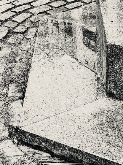 Buildings reflected on wet stone