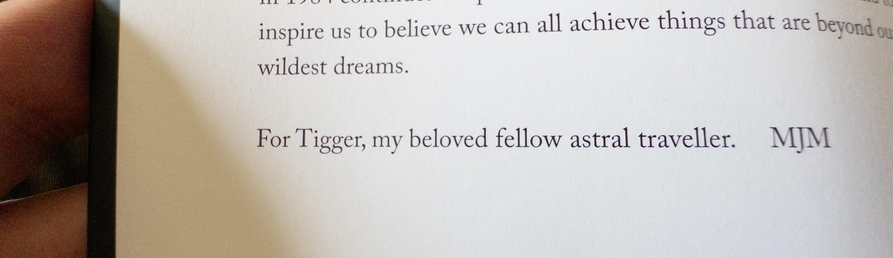 A close-up shot of a page from a book, featuring text that dedication that reads, "For Tigger, my beloved fellow astral traveller. MJM”