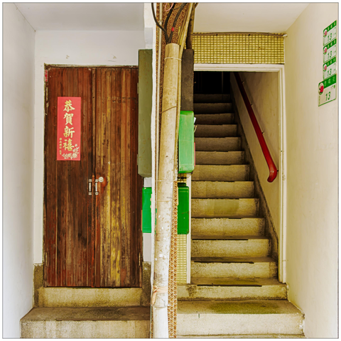 A closed door and an open staircase side by side in a residential building.