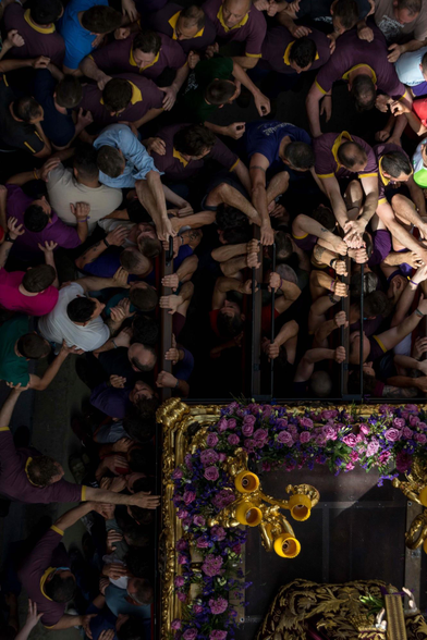 Multitud de costaleros se amontonan y empujan durante la procesión del Viernes Santo para poder conseguir un sitio en los varales de Jesús Nazareno. Una particular forma de vivir y sentir el Viernes Santo.