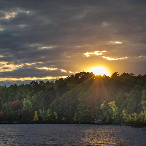 Autumn sunset over White Iron Lake.  The sun is partially obscured by clouds. 

Ely, Minnesota 