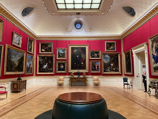 A big hall with many paintings hung on the wall inside The Wallace Collection museum