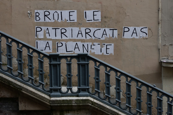 writing on the wall "burn patriarchy and not the planet"
