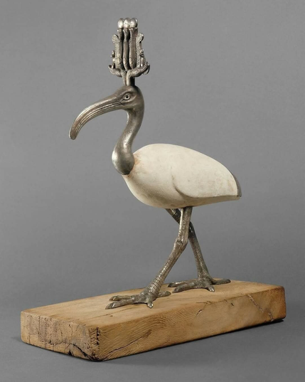 Thot, incarnation de la sagesse et de l’art de l’écriture, était le protecteur des scribes. L’ibis et le babouin étaient les animaux sacrés du dieu Thot. Le corps de cette statuette est en bois recouvert de stuc raffiné. La tête, coiffée de la couronne atef, le cou, les plumes de la queue et les pattes sont en argent. Les yeux sont en stuc et en verre noir.