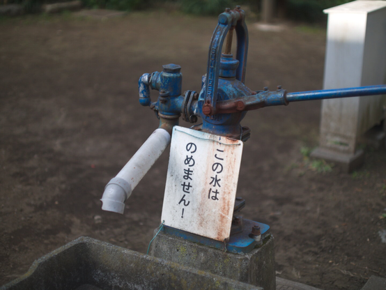 A water pump with a sign that it don't delivers drinking water