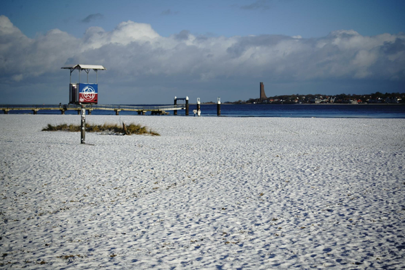 Ansichten vom Falckensteiner Strand unter eine dünnen Schneedecke. Der Himmel ist blau, teilweise liegt die Szene in gelbem nachmittäglichen Licht