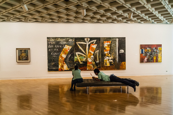Two schoolchildren relaxing in an art gallery