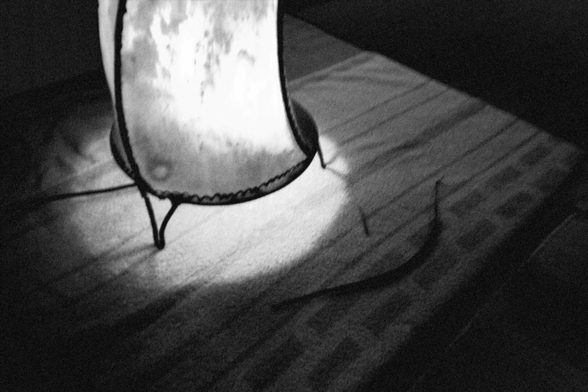 Lampe die auf dem Boden steht und leuchtet . Das Foto ist in schwarz-weiß fotografiert
