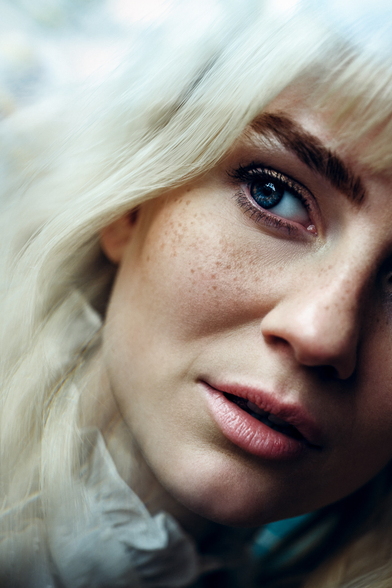 Closeup foto einer blonden frau mit blauen augen und Sommersprossen.