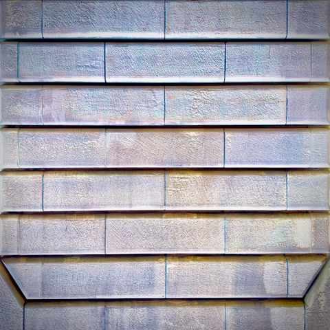 A sand-colored stone wall of large, horizontal bricks fills the frame, with a chamfered border carved into the bottom corners.