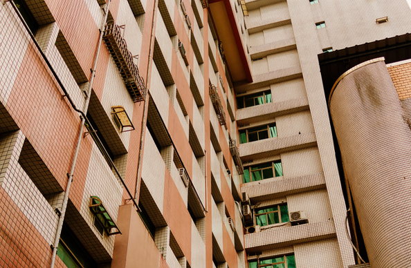 Detail of a residential facade with tiling, ACs, and balconies.