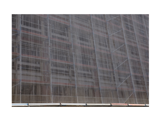 scaffolding on a building in lisbon with semi see through mesh fabric. shot taken from an odd angle, picture runs out of balance in top left corner.