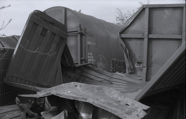 Black and white photography of crashed train wagons.
