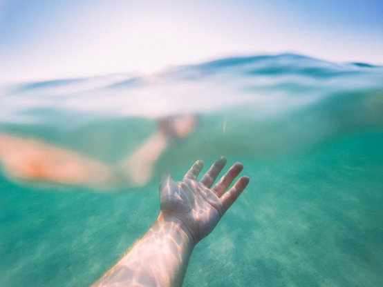 Photo of a hand just below the ocean surface