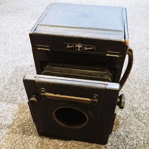 A black box with knobs and straps and a hole.  It could be a strange BDSM device, but it's not, it's an old wooden camera.  Sans lens. 