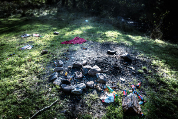 Feuerstelle mit liegen gelassenem Müll.