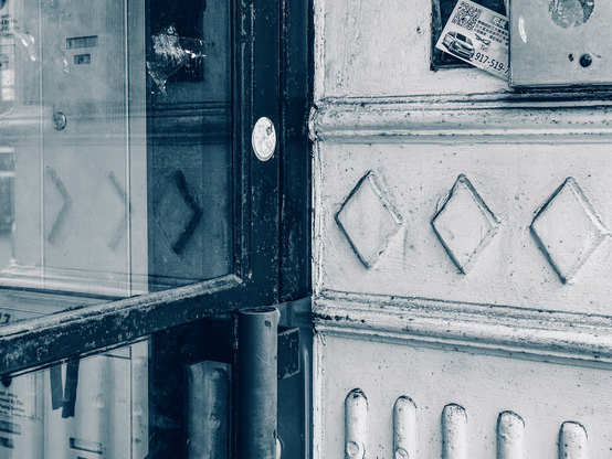 Wrought iron decoration of a wall by a glass door. The decorations are reflected in the glass