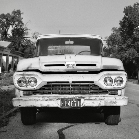 A black and white film photo. A classic 1960 Ford truck chills out on a nice sunny day in Gonzales, Texas. Sunday, June 1, 2025.