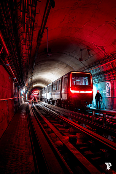a silhouette in a dark tunnel with a MP14 metro glowing red 
