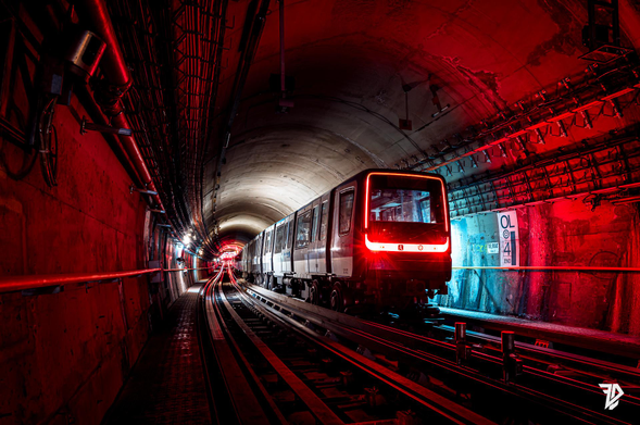 a dark tunnel with a MP14 metro glowing red 