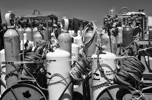 A large random collection of tanks, some with gauges and hoses. Black infrared sky behind them.