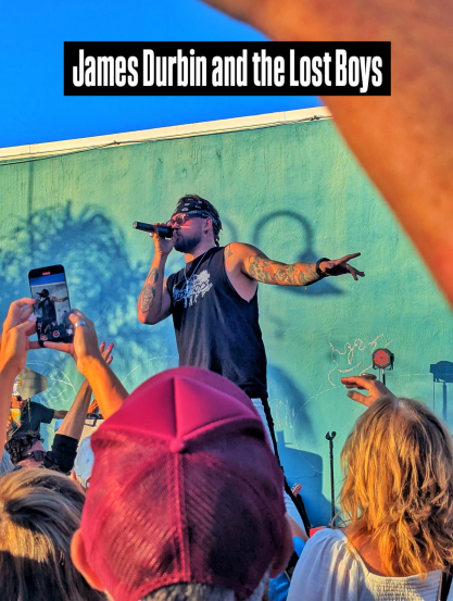 James Durbin standing over the crowd as he sings into the microphone.