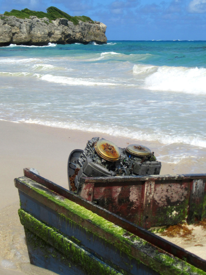 The image depicts a serene beach scene with a rocky outcrop in the background. The ocean is a vibrant turquoise, with gentle waves lapping at the shore. In the foreground, a large, rusted engine is partially buried in the sand, with green algae growing on its surface, indicating it has been there for some time. The engine is part of a larger, weathered structure, possibly a boat, which is also covered in algae. The sky is clear with a few scattered clouds, and the overall atmosphere is calm and tranquil.

Provided by @altbot, generated privately and locally using Ovis2-8B

🌱 Energy used: 0.155 Wh