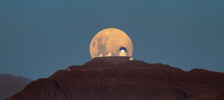 Another night of observing begins at the U.S. National Science Foundation Cerro Tololo International Observatory (CTIO) in the Chilean Andes, a Program of NSF NOIRLab, as the Moon sets below the horizon. The Moon appears massive and with a mysterious yellowish glow as it retreats behind the SMARTS–GSU 0.9-meter Telescope on the left, the SMARTS–GSU 1.5-meter Telescope in the center, and the Víctor M. Blanco 4-meter Telescope on the right. Both the SMARTS-GSU telescopes are operated by the Georgia State University Research Foundation. 