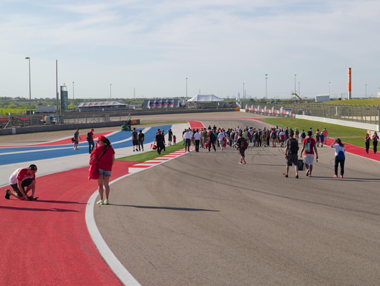 A group of people walking on the track at COTA raceway