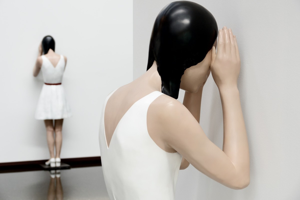 Two figures of girls looking at a wall