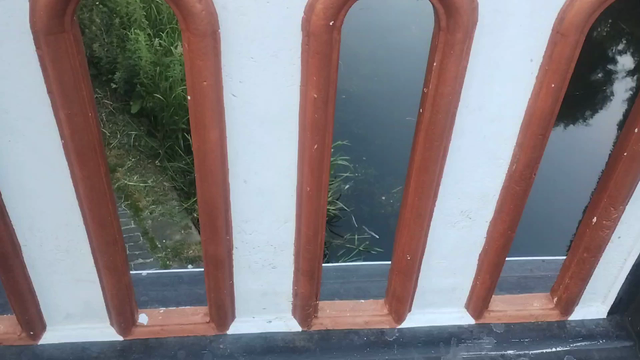 Video starts looking through decorative gaps in the bridge side, then up and over to give a clear view of the Union Canal below, evening light creating reflections in the water