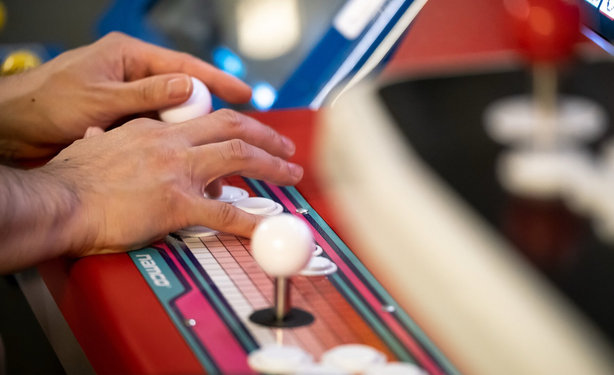 Hands close up of a person playing on an arcade cabinet.