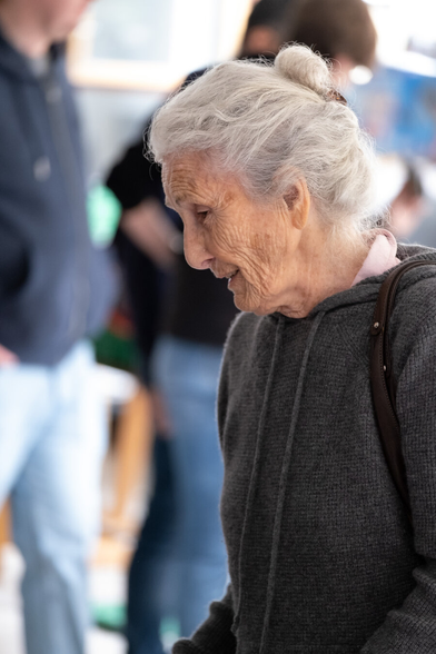 Picture of an old woman looking at articles at a wholesale.