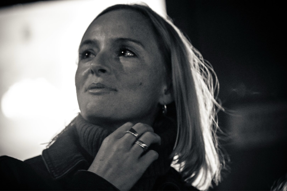 Black and white picture of a woman at night time.