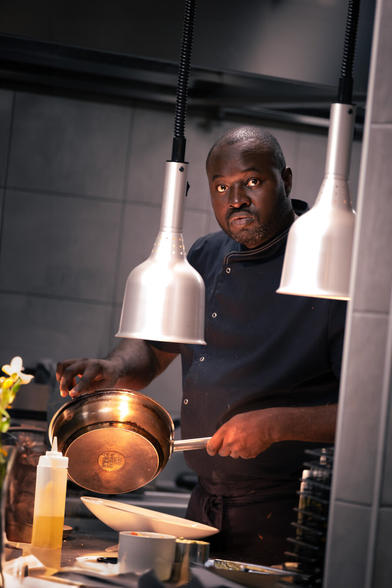 Picture of a cook dressing a plate in a restaurant.