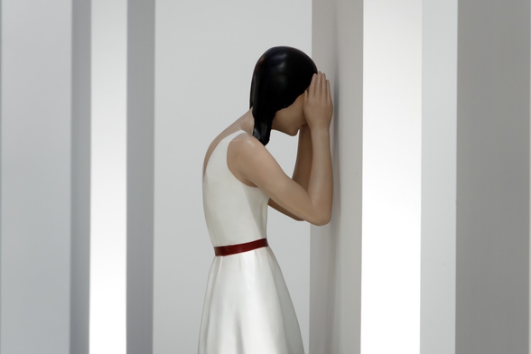 Upper part of a figure of a girl looking at a wall