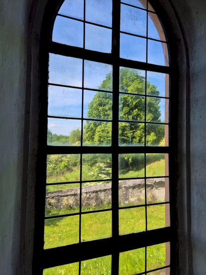 Blick hinaus ins Grüne durch ein Fenster der Kirche im oberfränkischen Ort Krögelstein