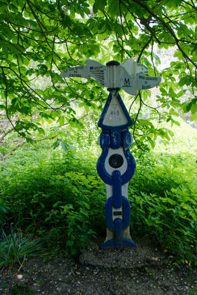 A blue chained post, with white infills. There are odd shaped pointers in white pointing in all directions. The text is in black but not readable.