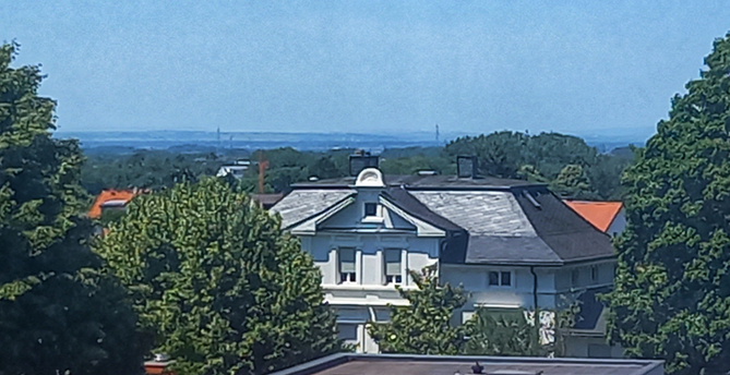 View over the rooftops with trees and a historical building with lattice windows