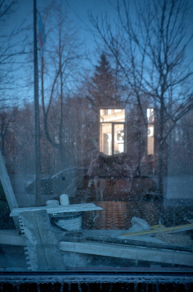 In the cold window, you can see another window brightly lit from the street. On the window, in the foreground, there are building materials and tools - the room is being renovated.