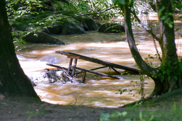 A broken picnic table in the middle of a swollen Rock Creek, June 2025.
